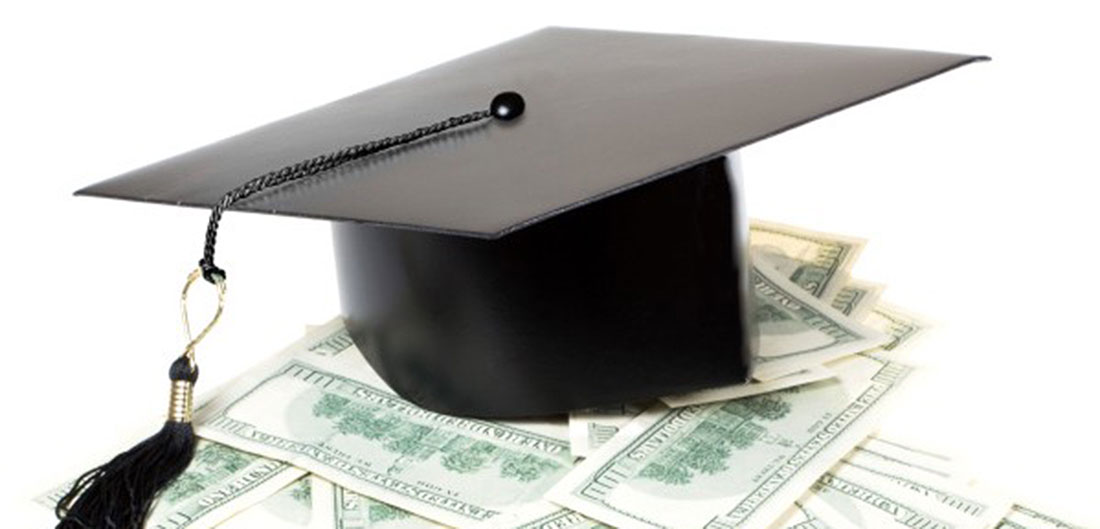a graduation cap sitting on top of money