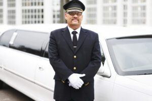 photo of a white limo with a Chauffeur standing in front of the limo