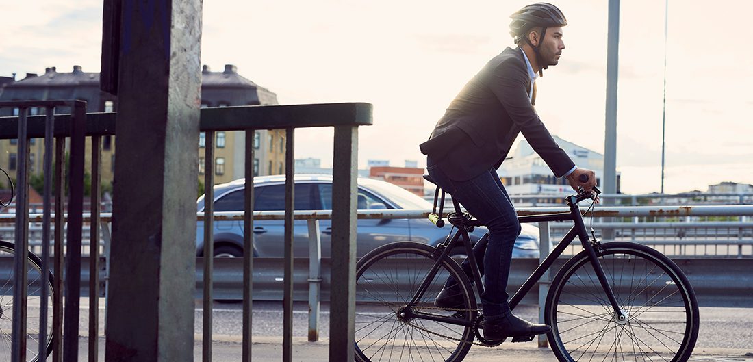 man in suit rides bicycle through urban landscape