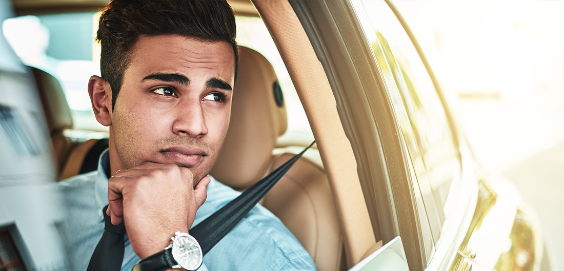 young man gazes distractedly out driver