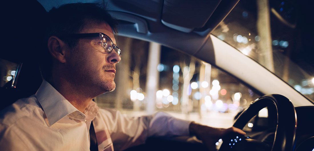 businessman drives car at night