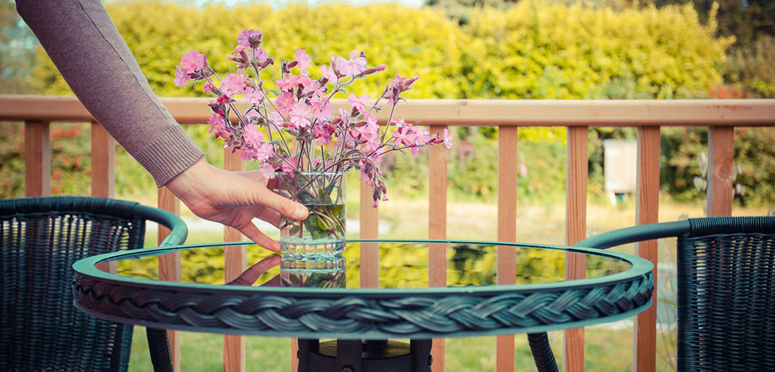 woman adding flowers to outdoor table