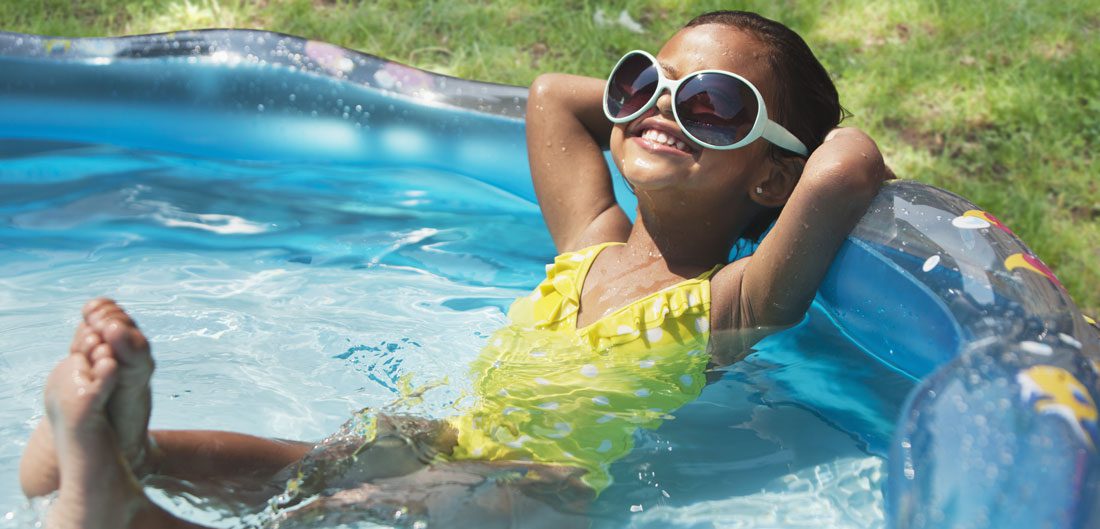 young girl relaxes with sunglasses in kiddie pool